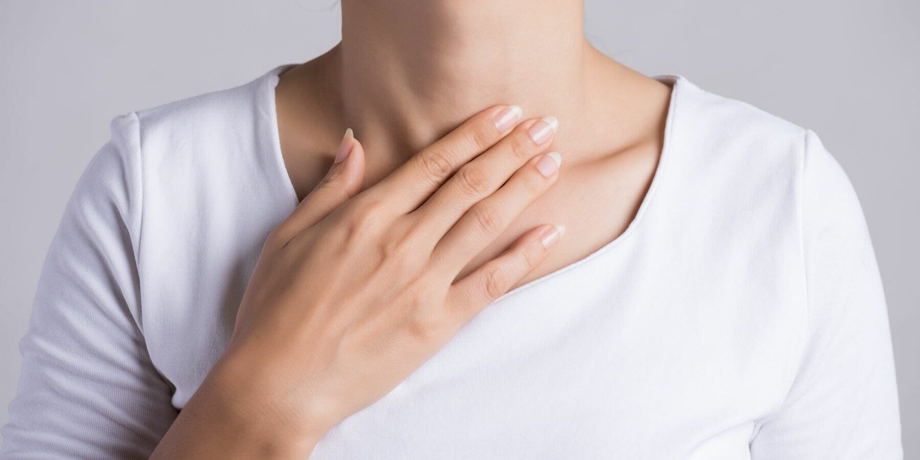 Sore Throat. Closeup Of Beautiful Young Woman Hand Touching Her Ill Neck. Healthcare and medical concept.